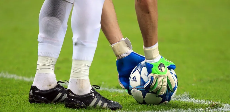 The football sits on the pitch before a soccer match.