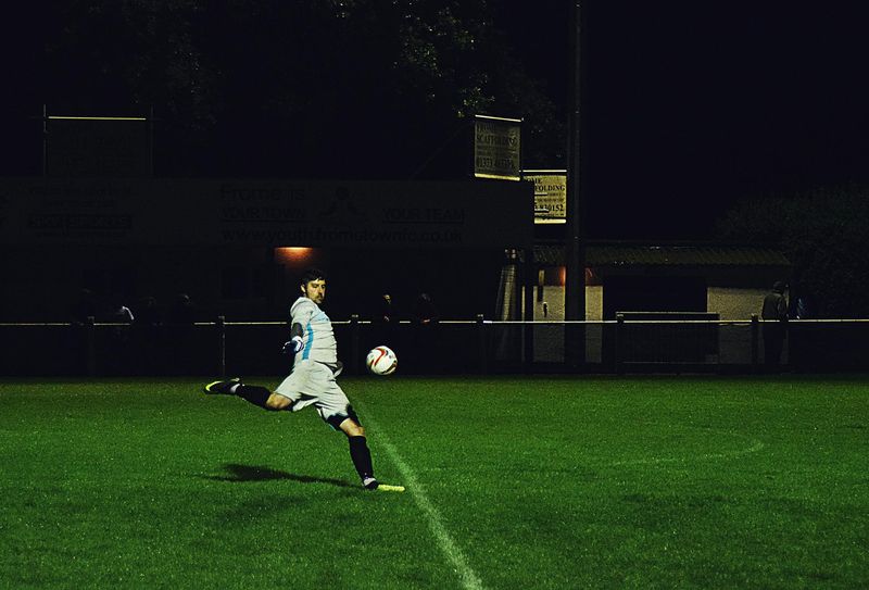 Man kicks the soccer ball in the field